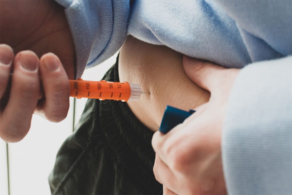 Person injecting Wegovy into their stomach.