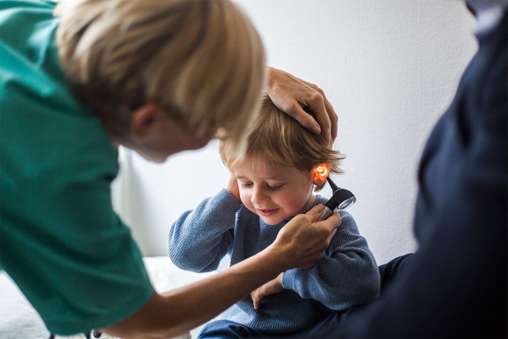 Young boy gets ear exam at pediatrician's office, possibly through Medicaid benefits