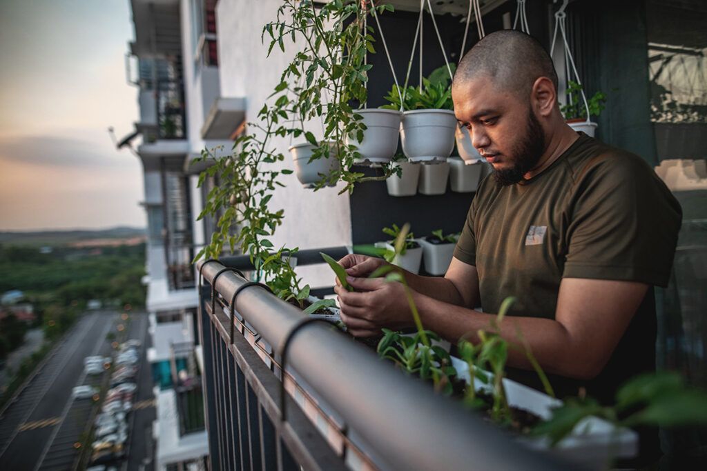 Man doing gardening in his balcony while feeling tired from statin drug use