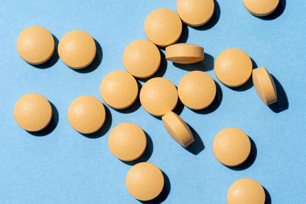 Some yellow Farxiga pills that help the kidneys on a blue background
