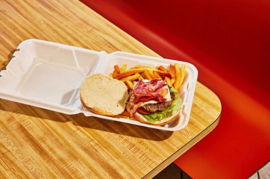 A container of a burger and fries, foods to avoid if you're taking pantoprazole.