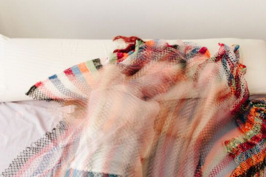 A person experiencing vivid dreams and nightmares induced by medications. They are blurry and lying on a colorful blanket.