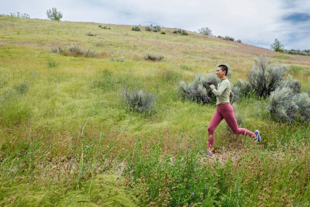 A young adult running through a field, representing a way to boost your metabolism.