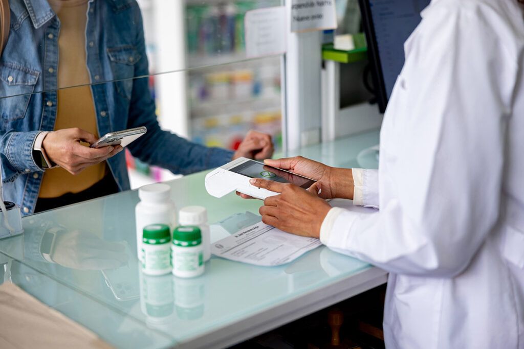 close up of a pharmacists tapping a prescription card as we look at how to check whether your medication is covered by insurance