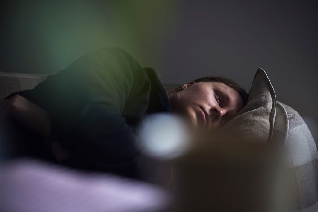 Female laying in bed with her eyes open to depict insomnia.