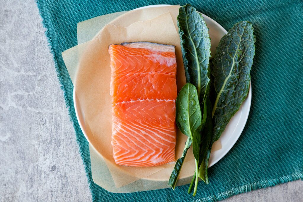 A plate of salmon and kale to depict the benefits of the DASH diet.