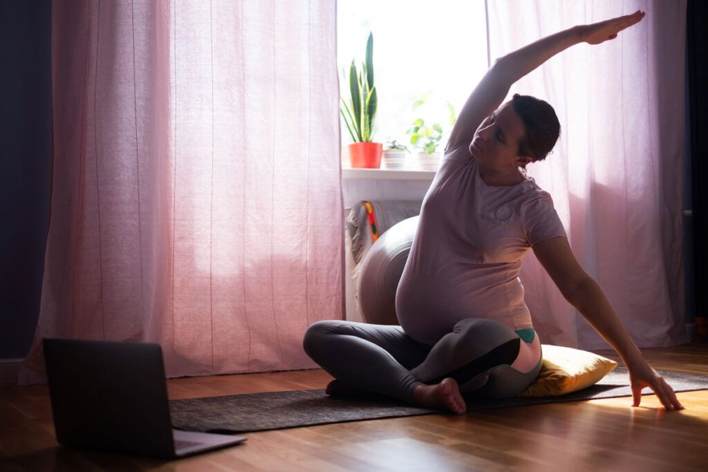 A pregnant person stretching. They may have signs of gestational diabetes in the third trimester.