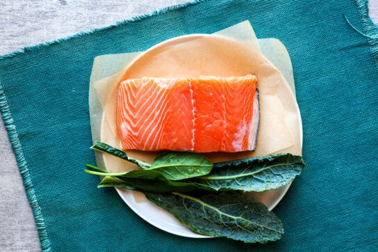 A plate with salmon and kale which could be part of a heart-healthy diet