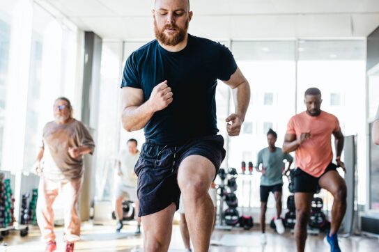 Adult males working out in a fitness class as one of the health habits to develop when understanding erectile dysfunction
