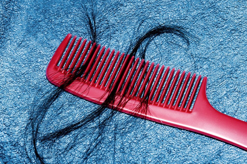 Loose hair in a comb to depict hair loss after Covid