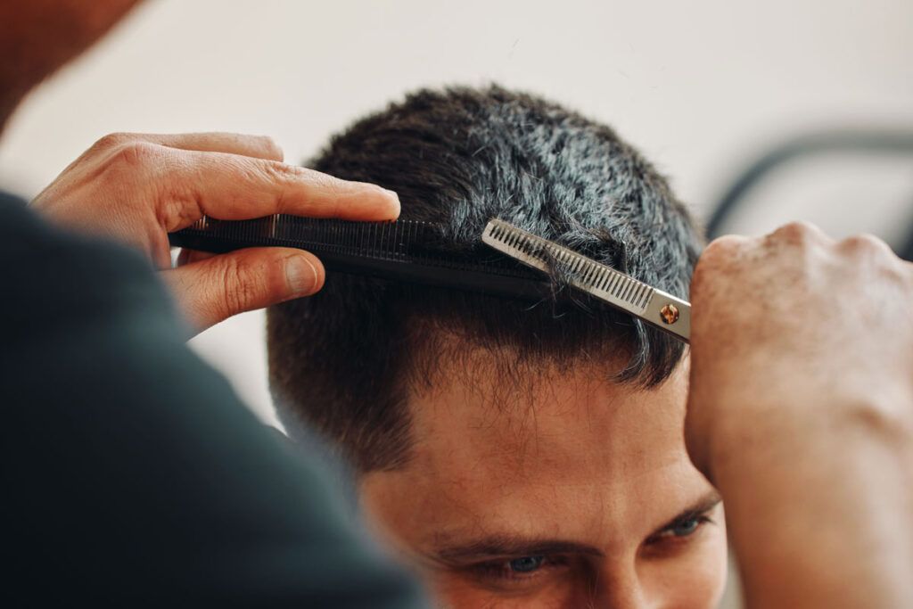 Close-up view of man getting haircut, possibly after hair loss treatment with OTC minoxidil