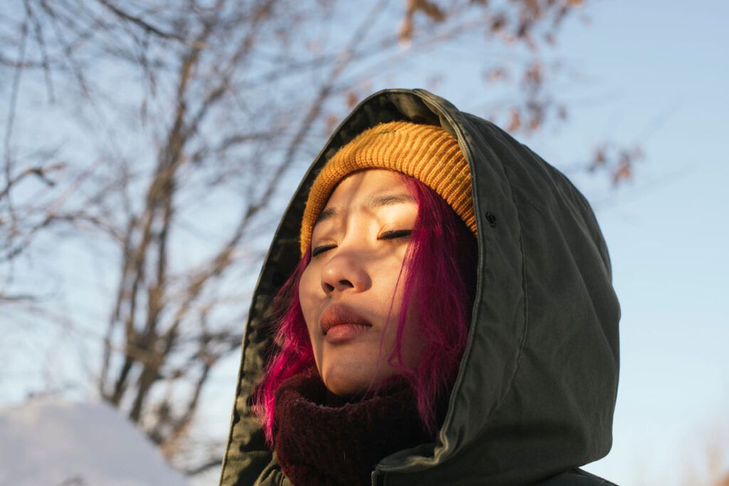 Female wearing a winter hat and coat stood outside to depict ways you get vitamin D during winter.