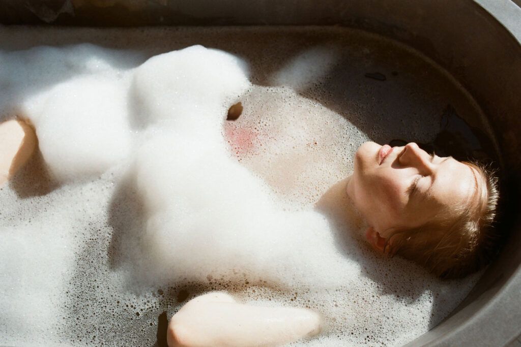 Female lying in a bath to depict ways to cure insomnia quickly.