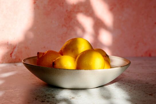 A large fruit bowl containing 5 visible lemons representing the types of foods that may provide immediate constipation relief at home