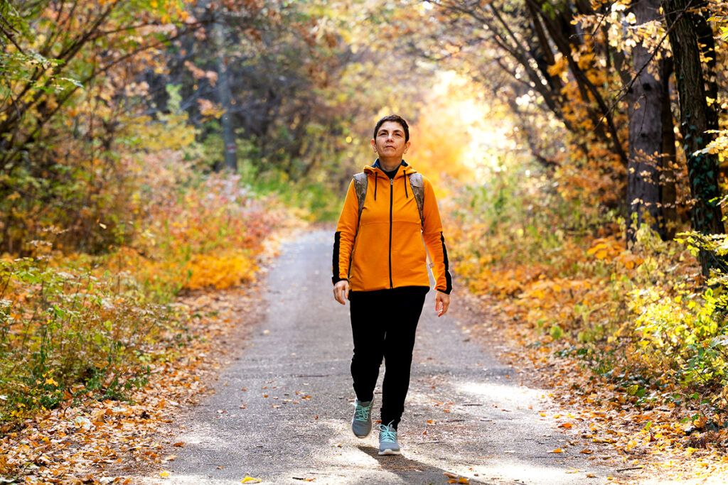 An adult woman out on a hike, considering what drugs to avoid with diverticulitis.