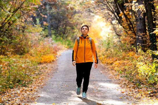 An adult woman out on a hike, considering what drugs to avoid with diverticulitis.