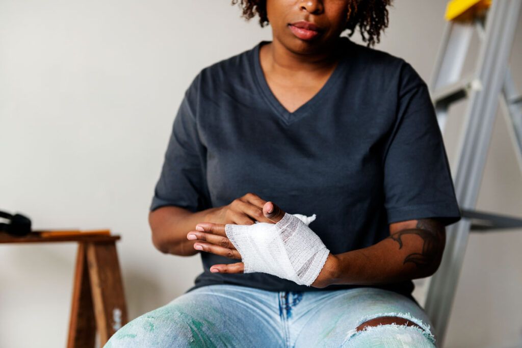 Person wrapping their hand in gauze to depict post-surgical care.