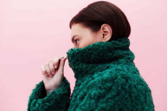 Woman in thick green fuzzy jacket with neck pulled up around her face