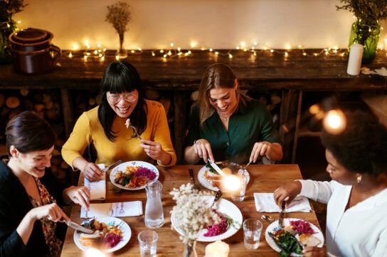 A group of women all enjoying a meal together and discussing IUDs and PMDD.