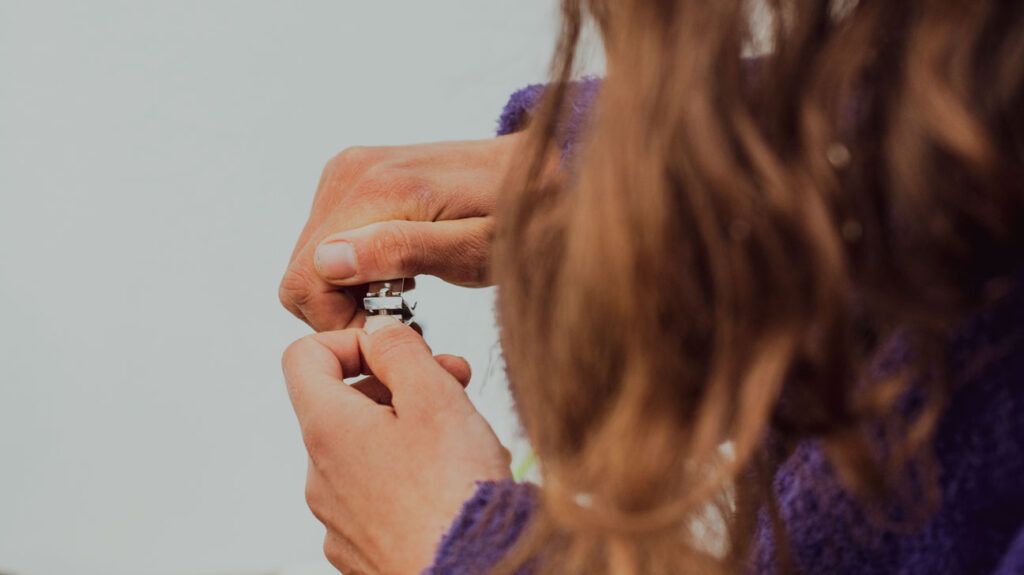 Close-up view of someone clipping their nails after their fungal infection has gone away