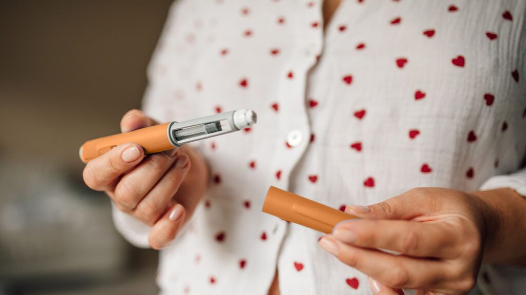 A person holding a GLP-1 pen.