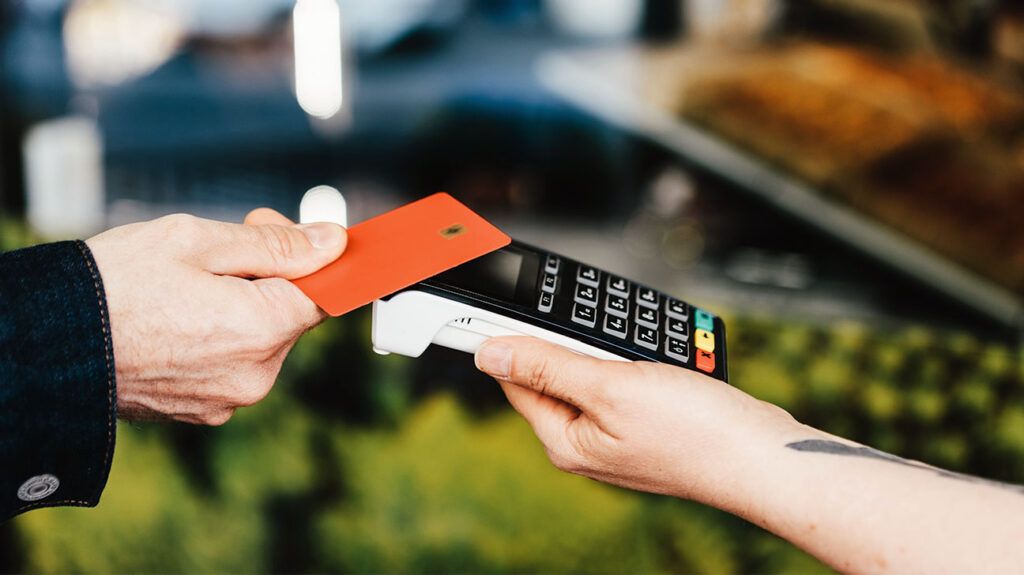 A person paying with a card for medications becoming more expensive in 2026.