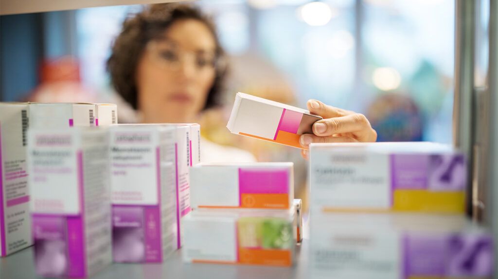 A person in a pharmacy comparing different medications.
