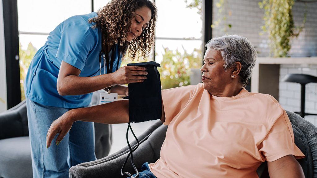 A nurse checking a patient's blood pressure.