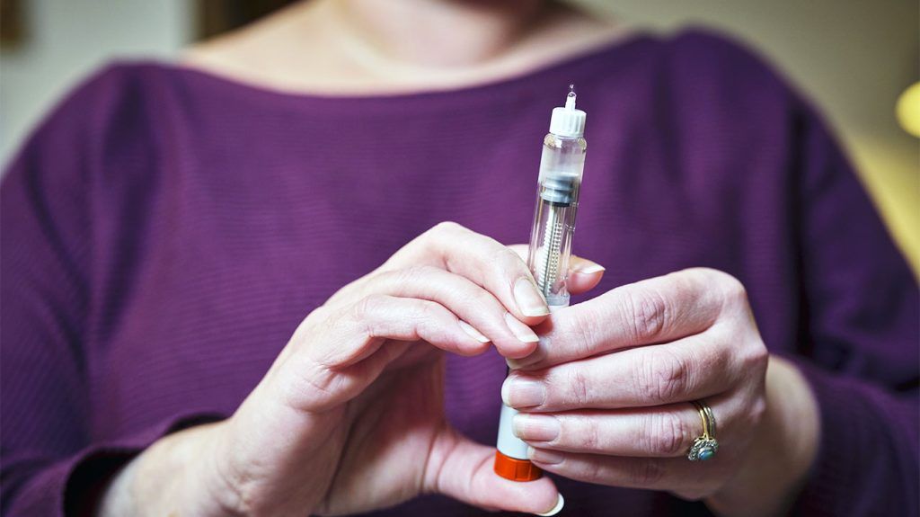 A person preparing a shot of a GLP-1 medication to self-administer.