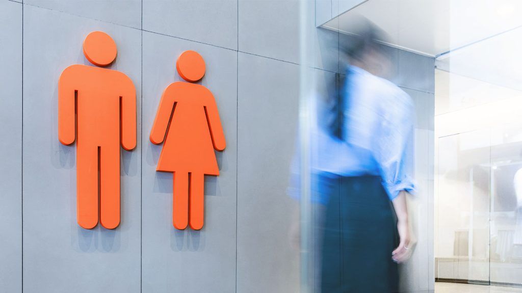 A person entering a public bathroom.