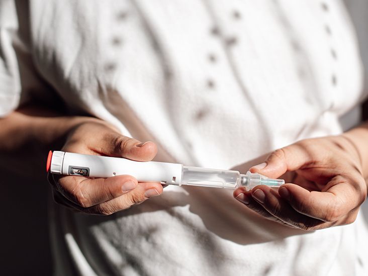 A person holding a GLP-1 injector pen.
