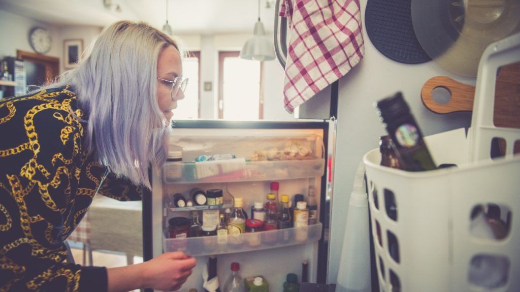 A person looking in the fridge, where their GLP-1 may be stored.
