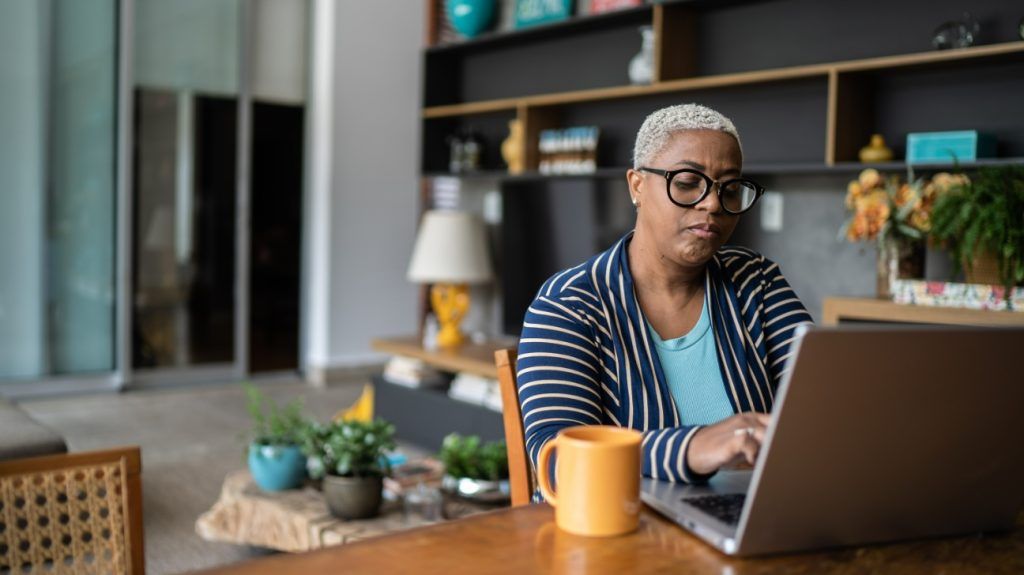 A person researching insurance on a laptop at home.
